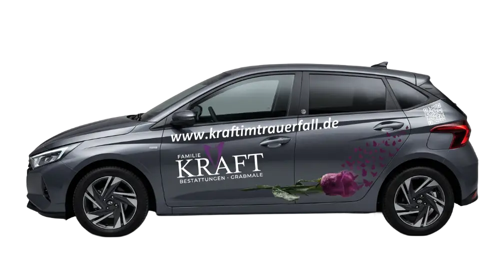Grauer PKW mit Beschriftung „Familie KRAFT Bestattungen • Grabmale“, Website www.kraftimtrauerfall.de, einer liegenden rosa Rose und QR-Code am Heck.