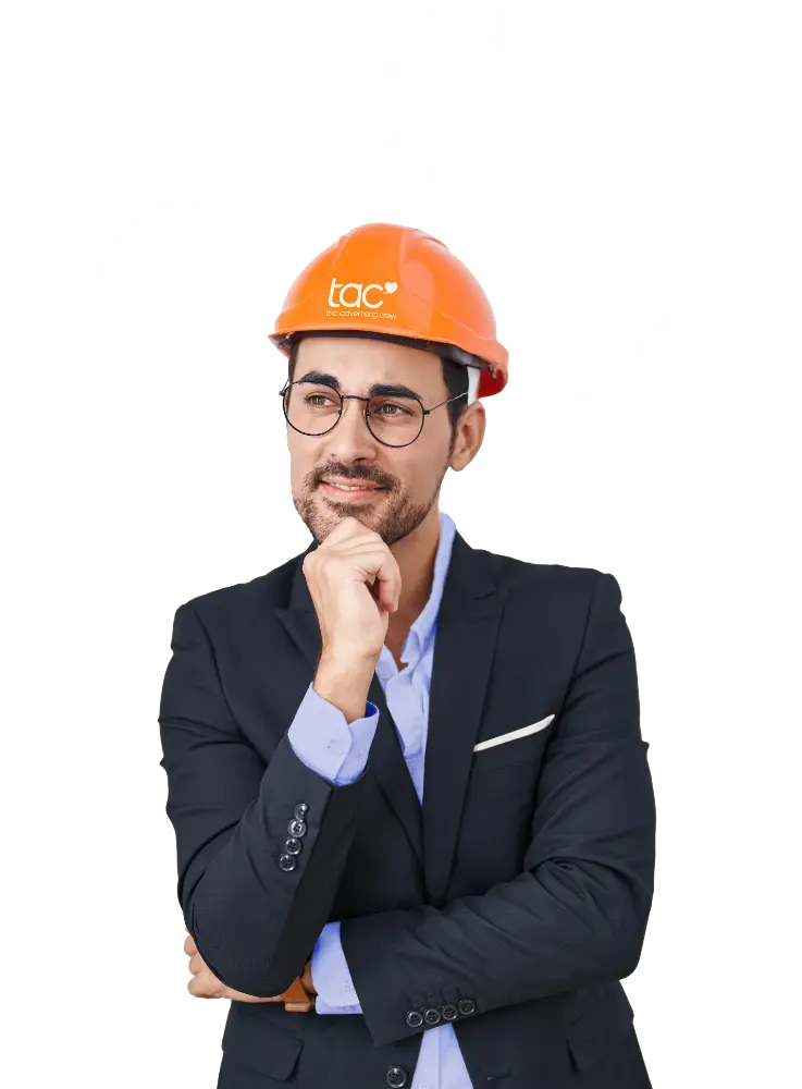 Ein lächelnder Mann in schwarzem Sakko, hellblauem Hemd und Brille trägt einen orangefarbenen Schutzhelm mit dem weißen Logo „tac the advertising crew“. Er hält nachdenklich eine Hand an sein Kinn und blickt nach links oben.